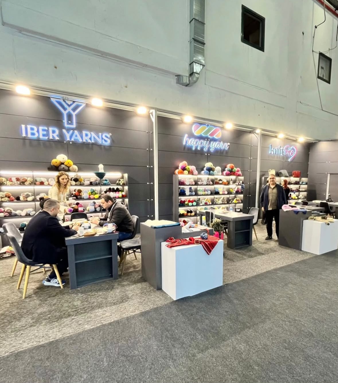 Iber Yarns fuar standının aydınlatmalı iplik rafları ve görüşme alanı